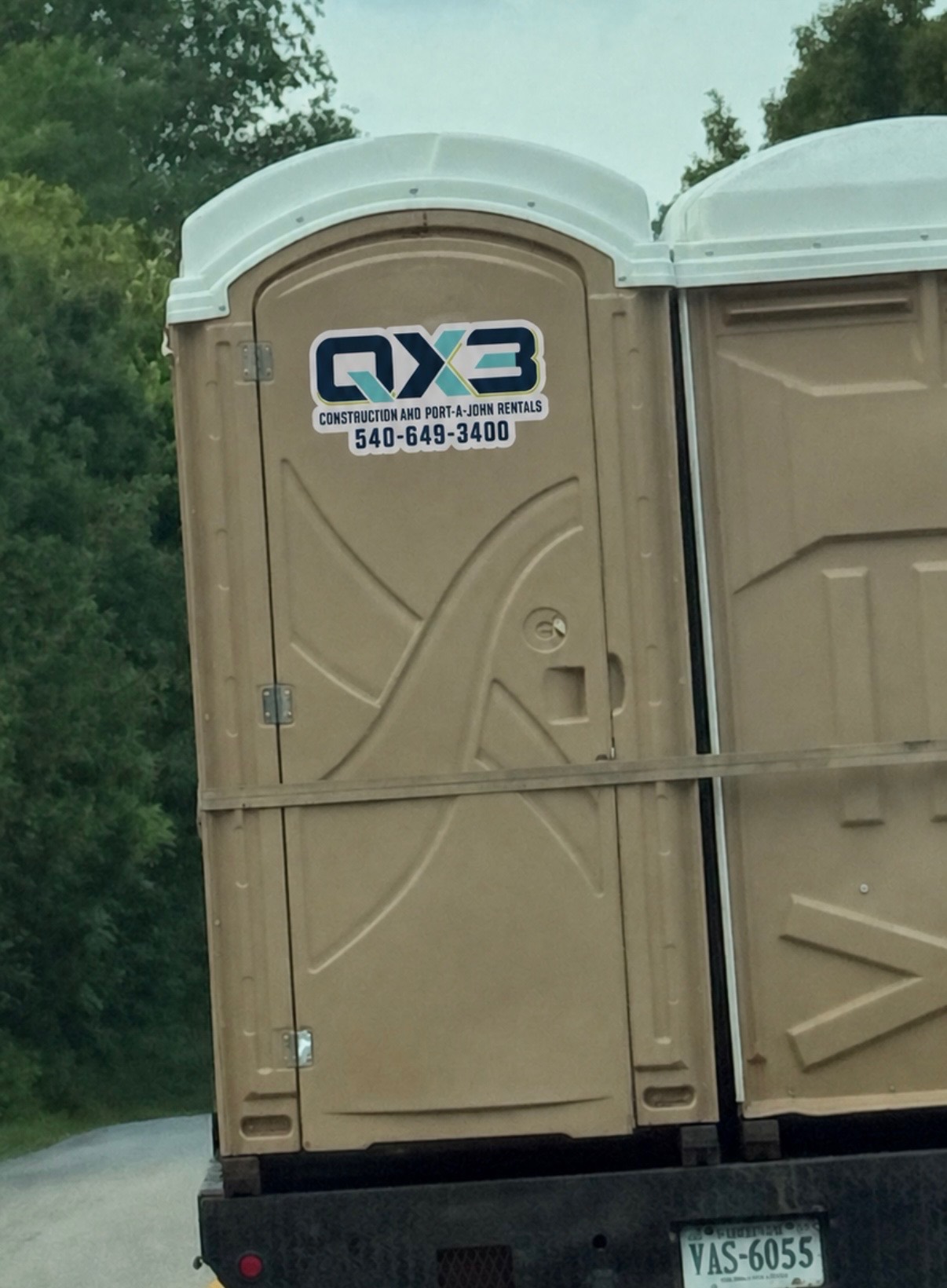QX3 branded standard portable restrooms loaded for delivery
